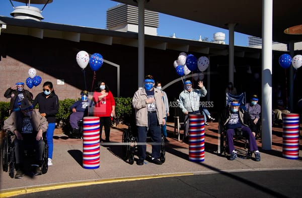 Residents and staff listen to the national anthem during a socially-distanced Veterans Day ceremony at the Southern Nevada St