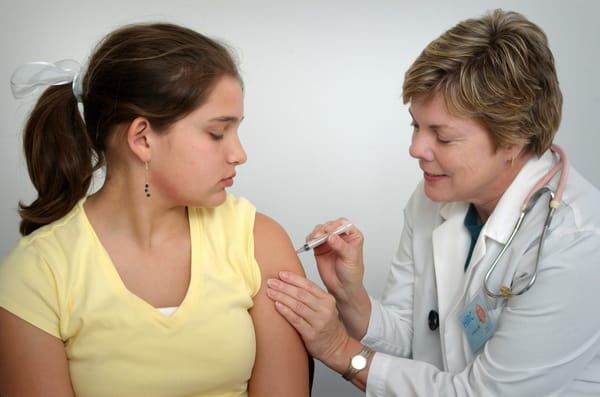 a nurse giving a vaccine in a health care medical office